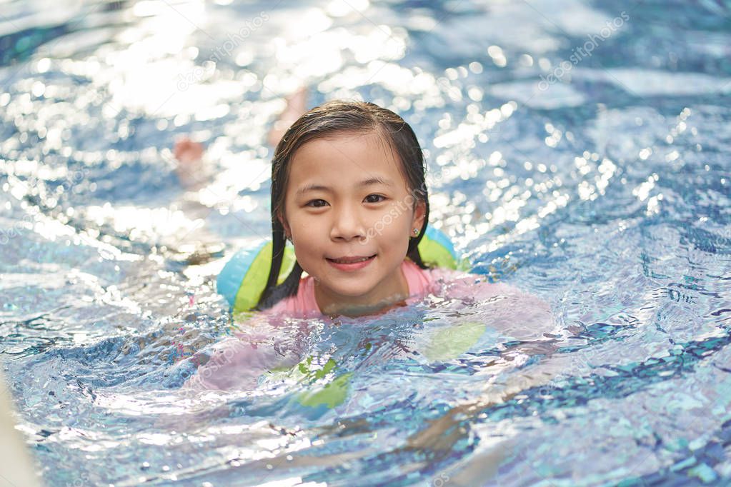 Asian little girl have fun in swimming pool 