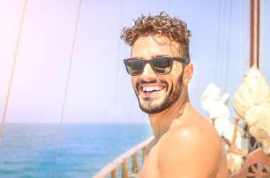 Neşeli adam özel lüks yelkenli tekne üzerinde kendi kendine portre almak. Dostluk ve genç insanlarla seyahat kavramı. Mutlu erkek arkadaşları ile vakit parlak güneşli renk tonu ile yaz gezisi sırasında