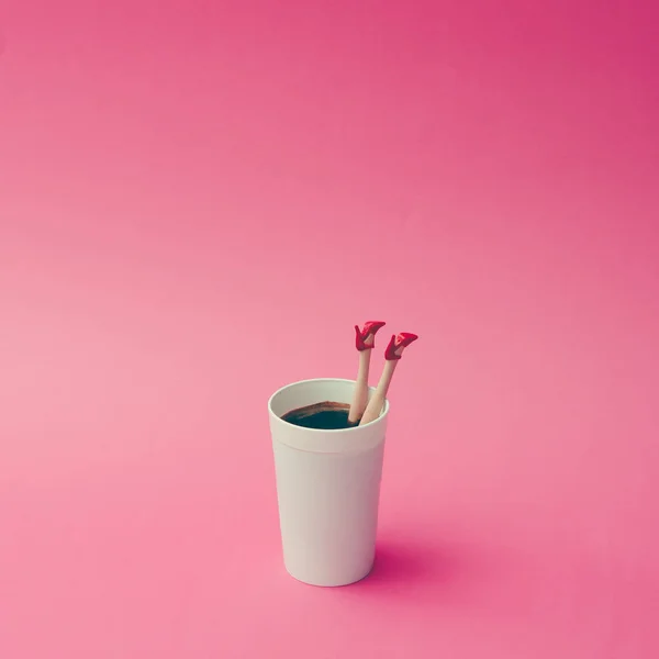 Koffiekopje met vrouwelijke pop benen — Stockfoto