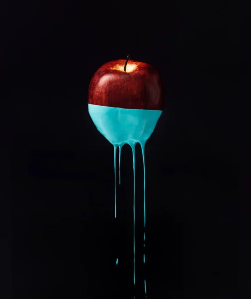 Red apple with dripping blue paint — Stock Photo, Image