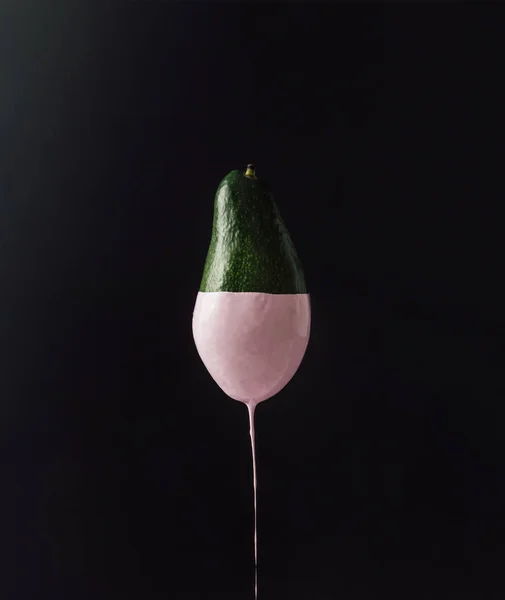 Avocado with dripping pink paint — Stock Photo, Image