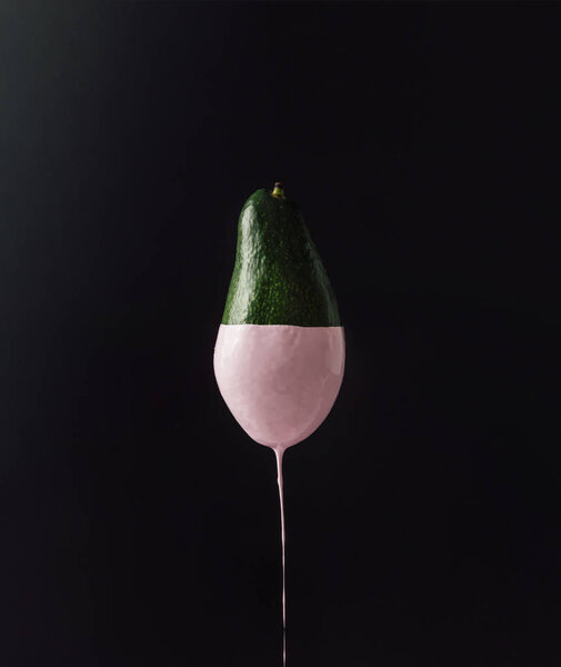 Avocado with dripping pink paint 