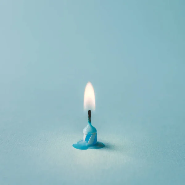 Burnt out candle on blue background — Stock Photo, Image