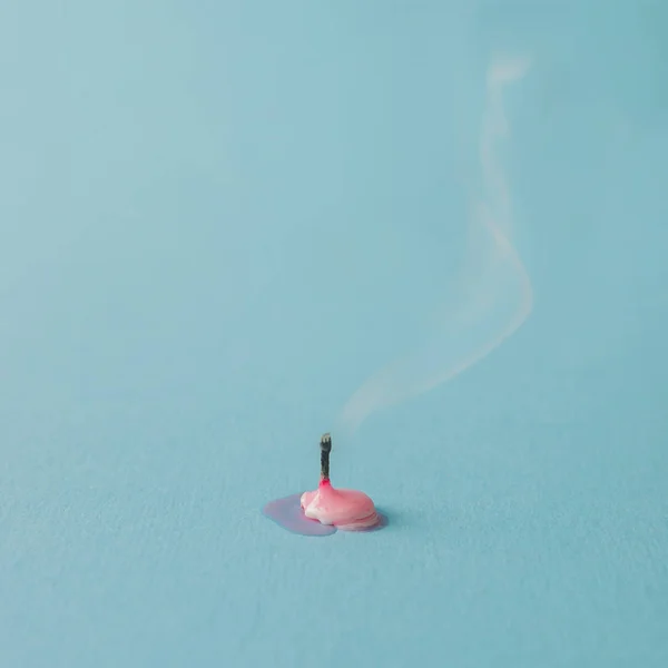 Membakar lilin merah muda di latar belakang biru — Stok Foto