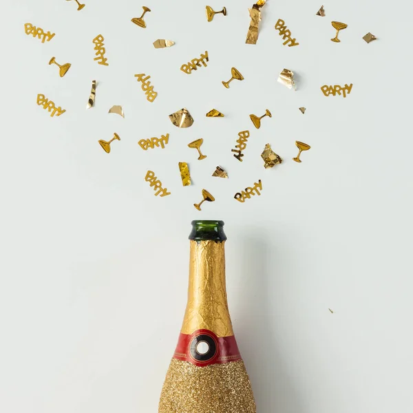 Gyllene champagne parti flaska med konfetti — Stockfoto