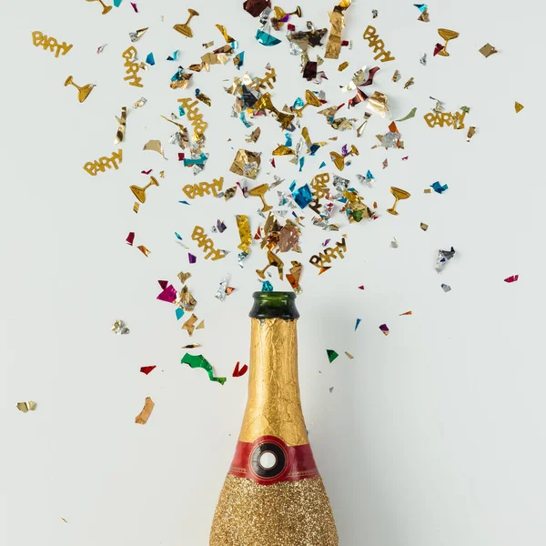 Golden champagne party bottle with confetti — Stock Photo, Image