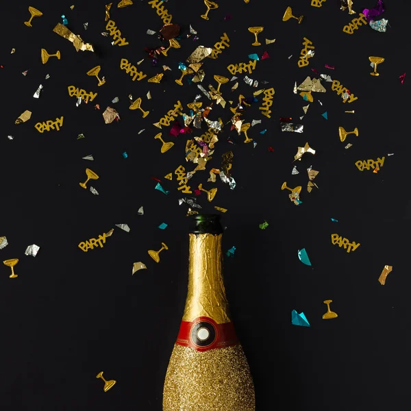 Gouden champagne partij fles met confetti — Stockfoto