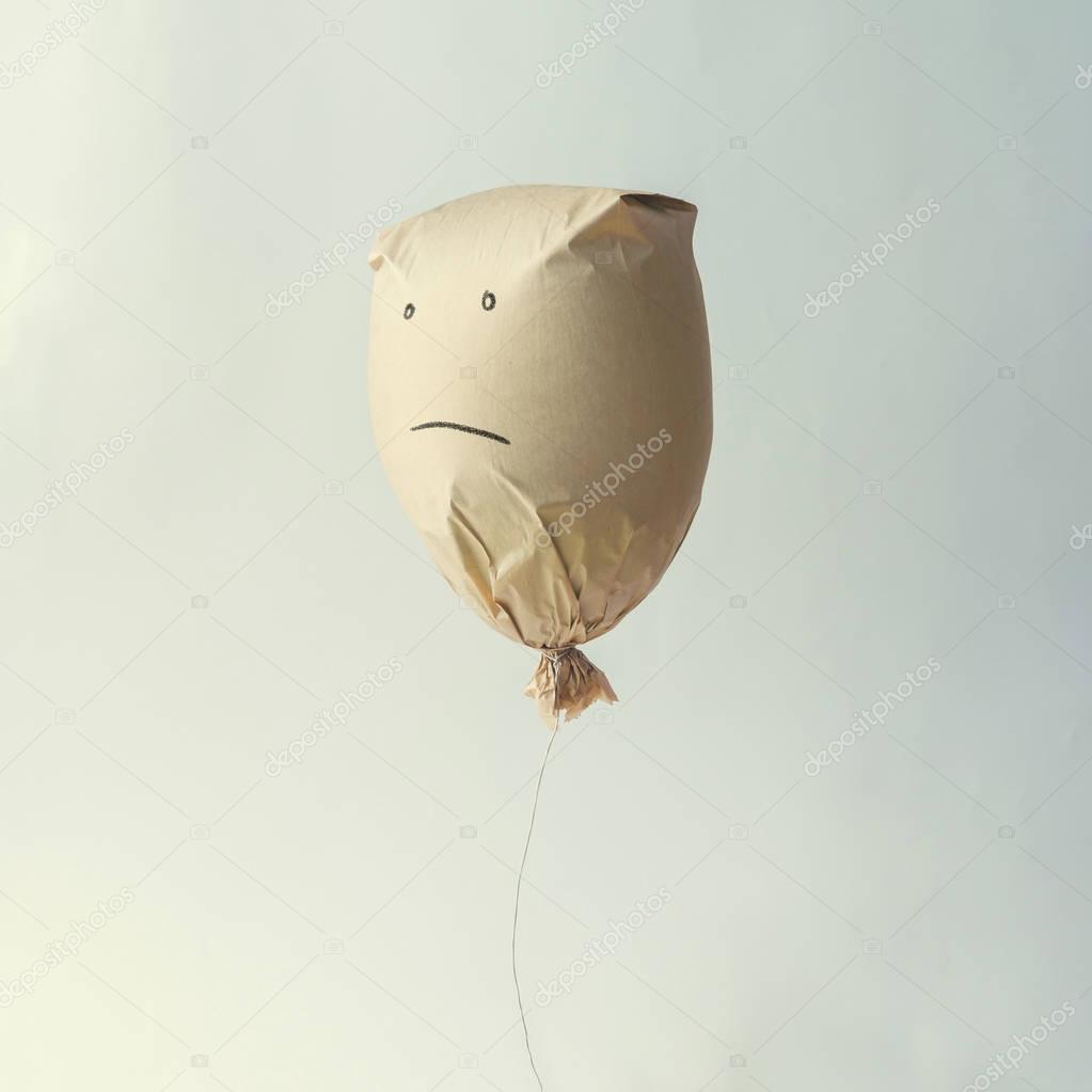 Paper bag balloon with sad face 