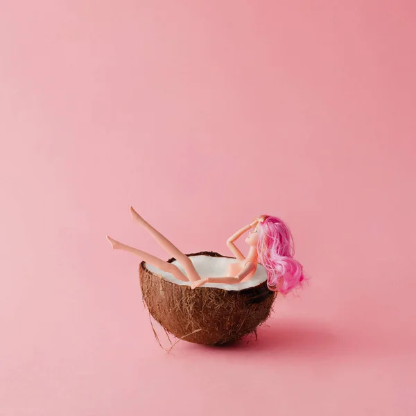 Boneca com cabelo rosa tomando banho no coco — Fotografia de Stock