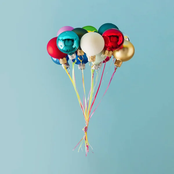 五颜六色的圣诞小装饰在蓝色背景下的气球 最小的圣诞概念 — 图库照片