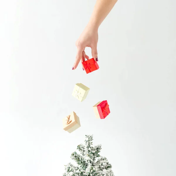 Weibliche Hand Wirft Geschenkschachteln Auf Den Weihnachtsbaum Minimales Kreatives Neujahrskonzept — Stockfoto