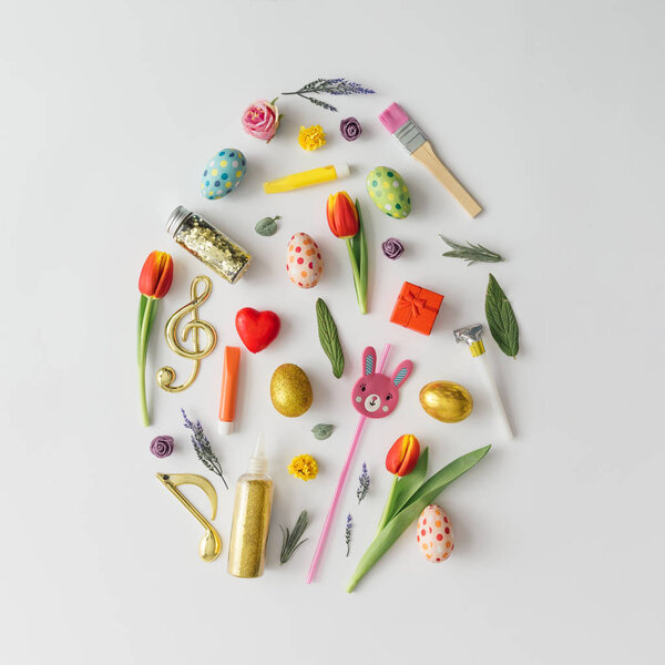 Easter egg shape made of various Easter decorative elements, minimal spring concept