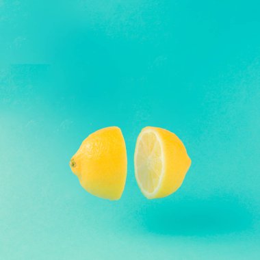 Lemon cut in half on pastel blue background. Minimal summer concept. Flat lay. clipart