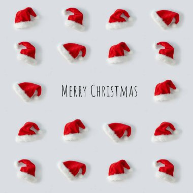 Yaratıcı Noel Baba şapkaları ve arka planda Mutlu Noeller mesajı. Minimum kış düzlüğü Noel konsepti 