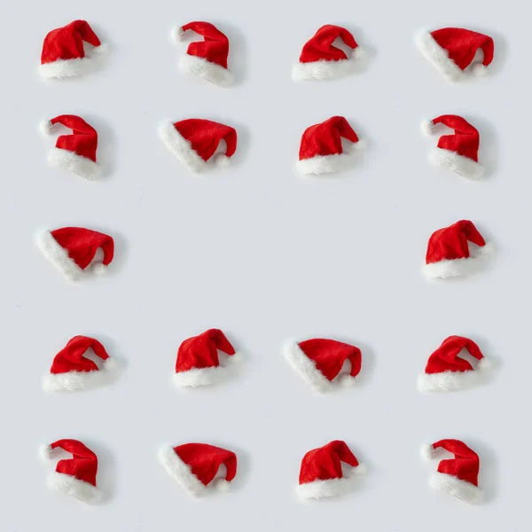 光の背景に創造的なサンタクロースの帽子 ミニマルな冬のフラットレイクリスマスのコンセプト — ストック写真