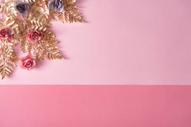 Creative layout made with pastel pink and purple flowers with gold leaves. Nature Trendy Decorative Design. 
