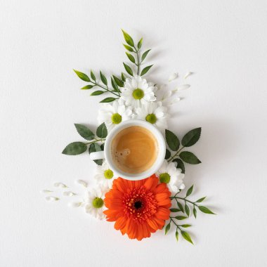 Creative layout made of pink and white flowers with leaves and coffee cup on white background 