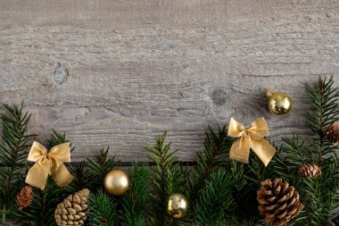 Christmas and New Year holiday background with fir branches and golden decorations 