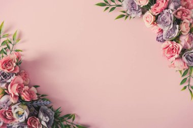 Creative arrangement of colorful flowers and green leaves on pastel pink background. Women day minimal concept