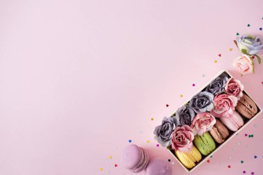Creative layout made with flowers and macaroons in box, Colorful spring flower background