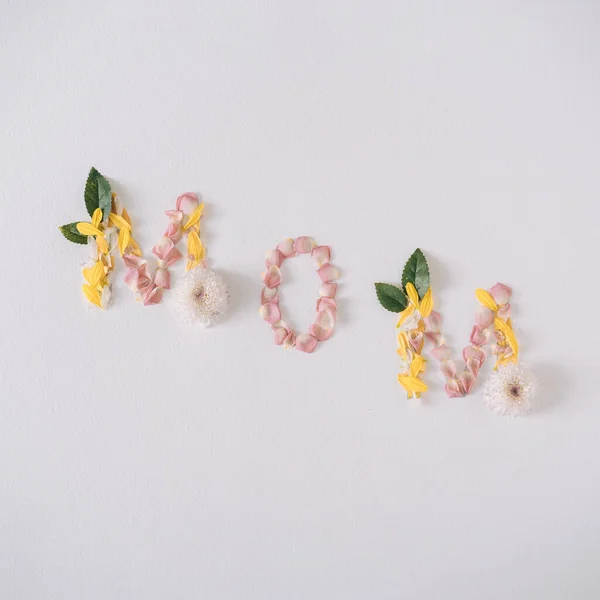 MOM word made with flower petals and leaves. Mother day natural creative concept background