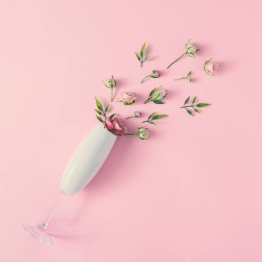 Pembe arka planda bahar çiçekleri olan şampanya kadehi, en düşük mevsim parti konsepti. Doğa çiçek fikri..