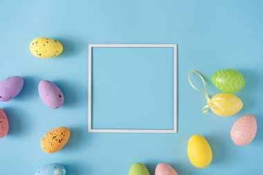 Renkli Paskalya yumurtaları ve pastel mavi arka planla yapılmış Paskalya yerleşimi. Asgari doğa geçmişi. Bahar tatili konsepti. Yaratıcı kopyalama alanı. Düz yatıyordu.