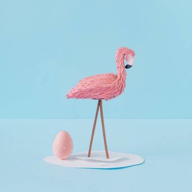 Flamingo ve pembe paskalya yumurtası ile yaratıcı kompozisyon. Minimum bahar ya da yaz tatili konsepti. Pastel eğlenceli arkaplan.