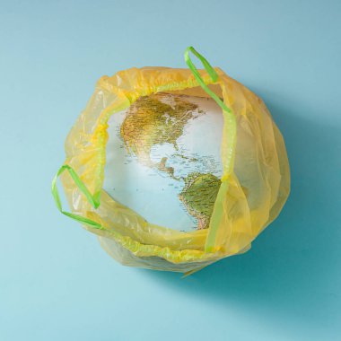 Yaratıcı kavramsal zeka gezegeni Dünya plastik çöp torbasında. Minimum düzlük.