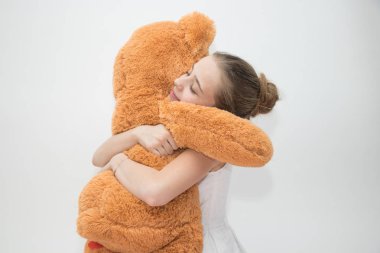 Genç kız büyük bir oyuncak ayı sarılma