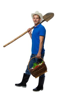 çiftçi bir kürek ile Çizmeli taze sebze Sepeti taşır