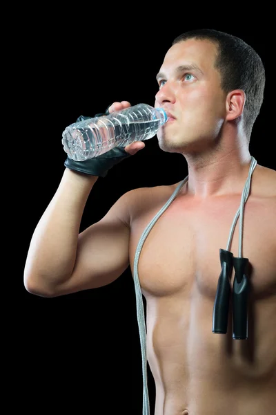 Atleta su sfondo nero acqua potabile da una bottiglia — Foto Stock