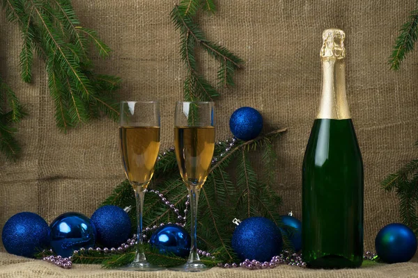 Butelkę szampana z dwa kieliszki do wina na tle oddziałów — Zdjęcie stockowe
