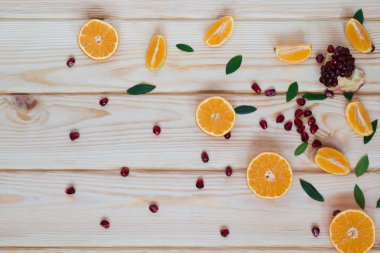 Tablo arka plan üzerine dilimlenmiş mandalina ve nar taneleri