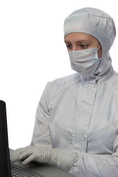 Ученый в защитном костюме работает с компьютером на белом фоне — стоковое фото