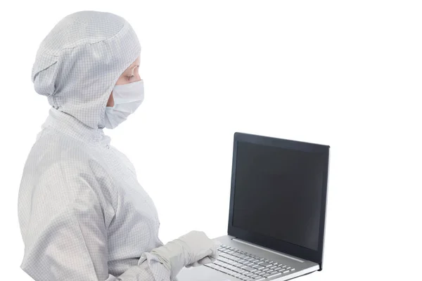 Forskare i en kostym och mask fungerar med datorn — Stockfoto