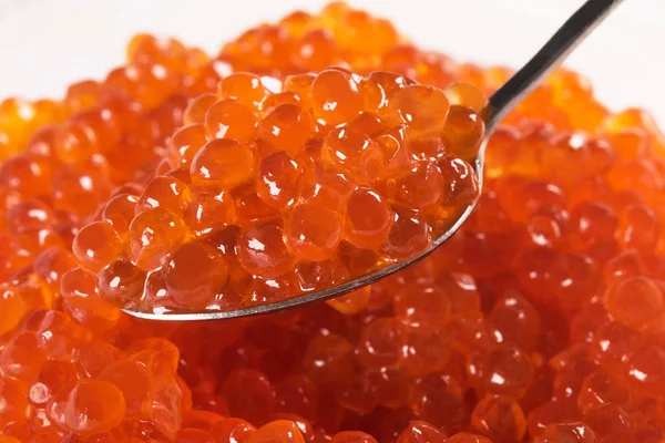 Spoon of red salmon caviar from banks as a background — Stock Photo, Image