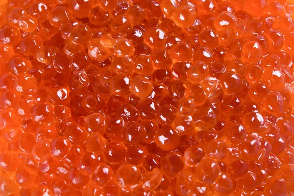 Goldener Hintergrund aus verstreutem rotem Kaviar — Stockfoto