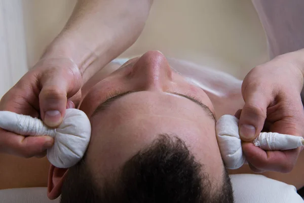 Herbal bags massage on temples head — Stock Photo, Image