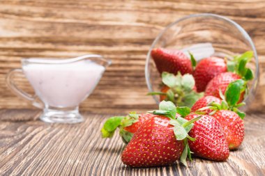 Kırmızı çilek ve yoğurt ahşap bir masa üzerinde arka plan