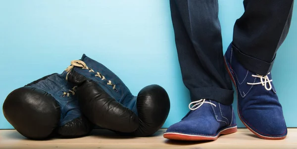 Боксерські рукавички поруч з чоловіком, який все ще в робочому одязі — стокове фото