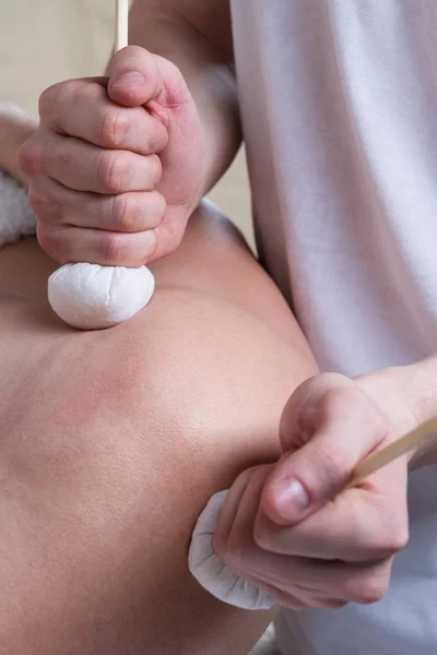 Schouder massage met kruiden zakken patiënt — Stockfoto