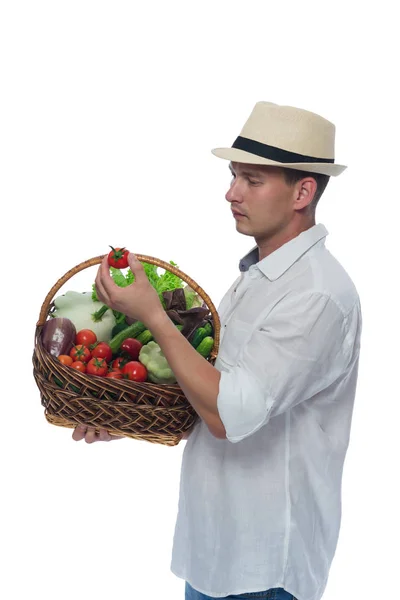 Granjero sacó de la cesta con verduras tomate y míralo — Foto de Stock