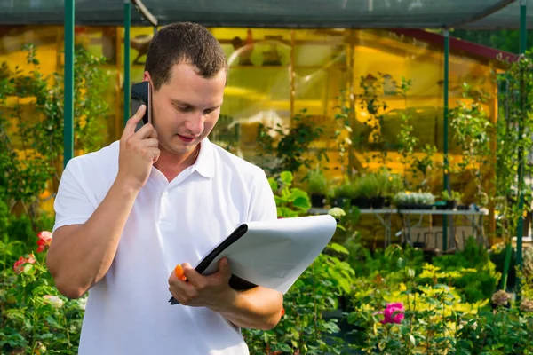 O vendedor de flores verifica por telefone as informações de entrega — Fotografia de Stock