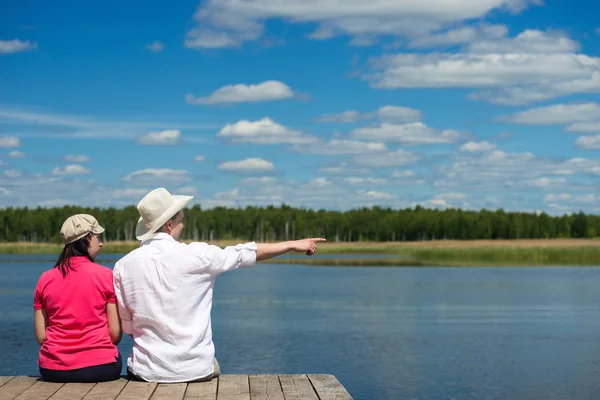 Aşıklar çifti göl kenarında oturup doğaya bakmak — Stok fotoğraf
