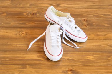 güzel beyaz spor ayakkabı koyu ahşap zemin üzerinde duruyorsun
