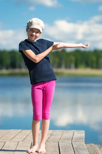 Молодая девушка стоит перед озером перед красивой природой — стоковое фото