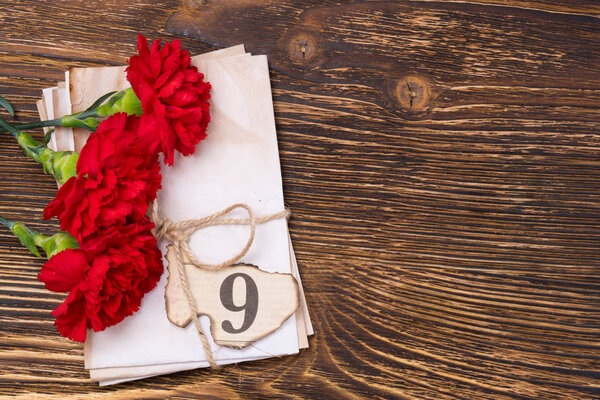 Background for postcard to the day of victory with carnations and retro papers