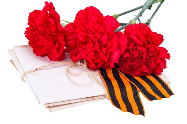 Куча писем, привязанных веревкой вместе с красными гвоздиками и лентой ко дню победы, на белом фоне — стоковое фото
