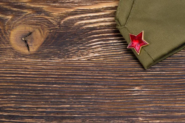 Vojenské čepice na dřevěný stůl a místo pro nápis — Stock fotografie